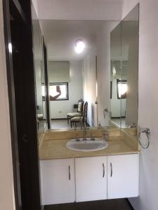 baño con lavabo y espejo grande en Lara en Mendoza