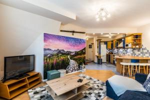 a living room with a large television and a giraffe mural at Apartament Bystry Potok in Zakopane