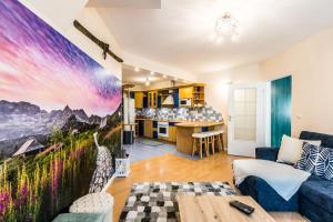 a living room with a couch and a kitchen at Apartament Bystry Potok in Zakopane