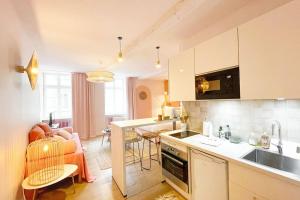 een keuken en een woonkamer met een bank en een tafel bij Appartement Dunes - Plage 50m - Rue gratuite in Saint-Malo