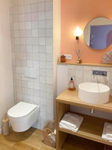 een badkamer met een wastafel, een toilet en een spiegel bij Appartement Dunes - Plage 50m - Rue gratuite in Saint-Malo