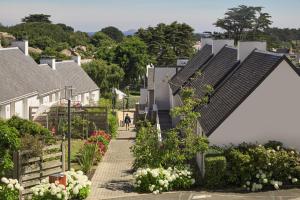 una fila de casas con paneles solares en sus tejados en Belambra Clubs Trégastel - Le Castel Sainte Anne, en Trégastel