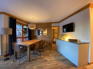 eine Küche und ein Esszimmer mit einem Holztisch und Stühlen in der Unterkunft Big Tartiflat, Arc 1950, 2 bed ski-in ski-out in Bourg-Saint-Maurice