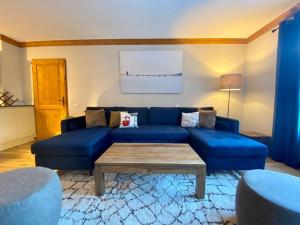 a blue couch in a living room with a table at 2 bed in Prince des Cimes Residence - Ski in Ski out - Arc 1950 in Bourg-Saint-Maurice