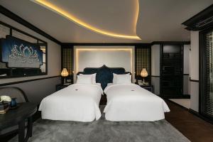 two beds in a hotel room with white pillows at LaPinta Boutique Cruises in Ha Long
