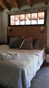 a large bed in a room with a window at Cabañas La Oma Intiyaco in Atos Pampa