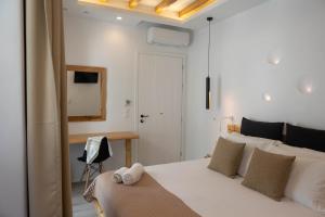 1 dormitorio con cama blanca y espejo en Studios Alsos, en Naxos Chora