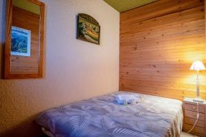 a small bedroom with a bed and a lamp at Welcoming apartment in the Alpe d'Huez - Welkeys in LʼHuez