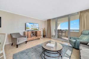 a living room with a couch and a tv at Perdido Sun 214 in Perdido Key