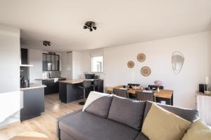 a living room with a couch and a dining room at Le Cocon Voltaire - Appartement 2 chambres avec parking - Mabilais in Rennes