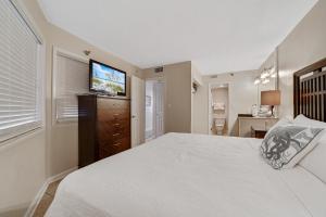 a bedroom with a bed and a flat screen tv at Perdido Sun 214 in Perdido Key +26 photos
