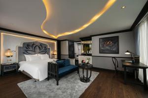 1 dormitorio con 1 cama grande y 1 silla azul en LaPinta Boutique Cruises en Ha Long