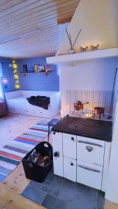 a kitchen with a stove and a bed in a room at Gårdshus in Lit