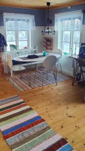 a living room with a table and chairs on a rug at Gårdshus in Lit