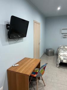 a living room with a table and a tv on a wall at lolly in Paravati