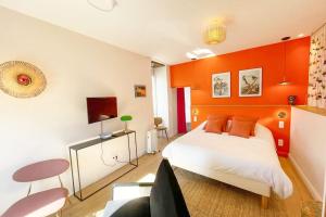 sypialnia z pomarańczową ścianą i łóżkiem w obiekcie Appartement Frida - Plage 50m - Rue gratuite w Saint-Malo
