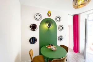 une salle à manger avec une table et des chaises vertes dans l'établissement Appartement Frida - Plage 50m - Rue gratuite, à Saint-Malo