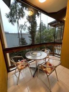 - Balcón con mesa y 2 sillas en Apto aconchegante a 500m da Rua Coberta c/ garagem, en Gramado