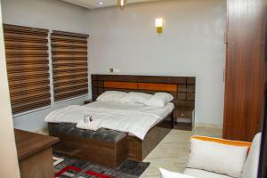 1 dormitorio con 1 cama grande y 1 silla en House 13, Wuye Abuja, en Abuja