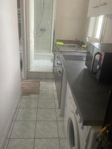a kitchen with a sink and a washing machine at RENT APPART - Colombes in Colombes