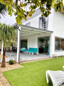 a white house with a patio with green benches at Dona Catarina Hotel in Florianópolis