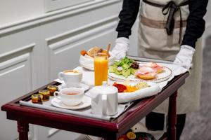 a person holding a tray of food on a table at VIZUALIZA Residence Hotel by HMG in Plovdiv
