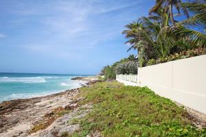 a white fence on the side of a beach at Rosalie Apt #2 by BSL Rentals in Christ Church