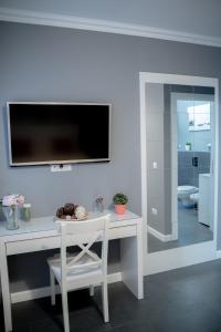 mesa blanca con silla y TV en la pared en Luxury Down Town, en Bucarest