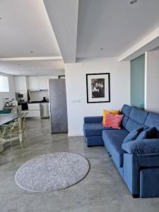 un soggiorno con divano blu e tavolo di Villa Gabriela Monte Estoril vista jardim 3 a Estoril
