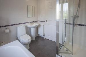 a bathroom with a toilet and a sink and a shower at Genesta in Saint Minver +8 photos