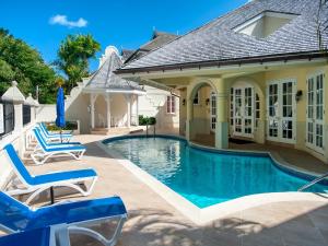 a house with a swimming pool and two lounge chairs at The Falls Townhouse 10 by BSL Rentals in Saint James