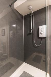 a shower with a glass door in a bathroom at No 31 Promenade APARTMENT by the sea in Aberystwyth