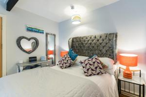 a bedroom with a bed with a headboard and a mirror at No 31 Promenade APARTMENT by the sea in Aberystwyth