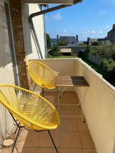 two yellow chairs and a bench on a balcony at Appartement Miramar - Plage 50m - Rue gratuite in Saint Malo