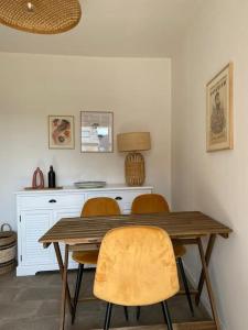 a dining room table with three chairs and a desk at Appartement Miramar - Plage 50m - Rue gratuite in Saint Malo