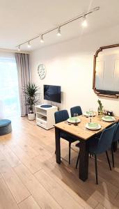 een eetkamer met een tafel en stoelen en een televisie bij CentroPark Apartament in Olsztyn