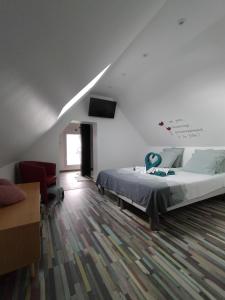 1 dormitorio con 1 cama y TV en la pared en La belle grange, en Saint-Étienne-au-Mont