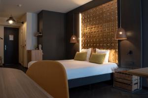 a hotel room with a bed and a brick wall at Hotel Brouwerij Het Anker in Mechelen