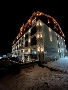 a building in the snow at night with lights at President Kop - Silver Ice Apartment in Kopaonik