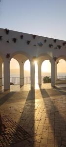 - un bâtiment avec des arches sur une jetée au coucher du soleil dans l'établissement Villa Azahar Anita, à Nerja
