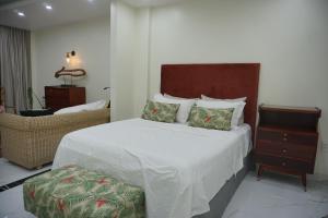 a bedroom with a bed and a chair and a table at Dahlia Homestay Tay Ho in Hanoi