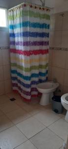 a bathroom with a shower curtain and a toilet at Cabaña Las Brisas in Plottier