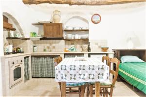 a kitchen with a table with a table cloth on it at Trulli Donna Isabella in Locorotondo