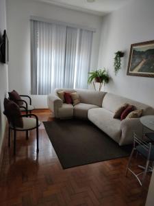 a living room with a couch and a table at Apartamento 2 dormitórios, wifi, ponta da praia, predio em frente ao mar - Santos in Santos