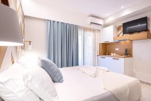 una camera da letto bianca con un letto e una cucina di Senso Deluxe a Limenaria