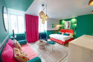 zieloną i czerwoną sypialnię z łóżkiem i kanapą w obiekcie Appartement Bollyroom - Plage 50m - Rue gratuite w Saint-Malo