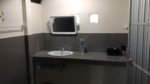 a bathroom with a sink and a tv on the wall at Loma Sea Views in Ko Jum