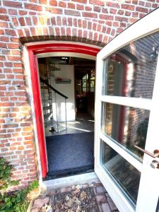 an entrance to a brick building with a red door at Boerderijlodge Kamperland in Kamperland