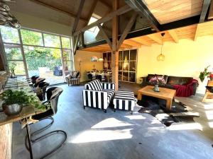 ein großes Wohnzimmer mit Stühlen und einer Couch in der Unterkunft Boerderijlodge Kamperland in Kamperland