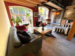 a living room with a leather couch and a table at Boerderijlodge Kamperland in Kamperland